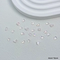 Vue macro de breloques à ongles coeur 3D translucides 4x5mm avec éclat iridescent - Clair Iridescent