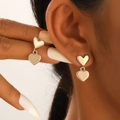 Twisted heart-shaped earrings in gold finish worn by model showing vintage texture - Double Heart Interlocking Style (K-040) / 41 KC Gold