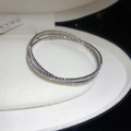 Primer plano de un brazalete cruzado plateado multicapa con pavé de circonitas brillantes - Brazalete Abierto de Doble Fila de Diamantes / Plateado