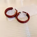 Close-up of elegant maroon glossy hoop earrings resting on textured rustic paper background - 15# Silver Post - Red