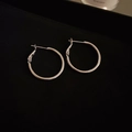 Close-up of minimalist silver hoop earrings with irregular circular design and metallic finish - Silver Medium Hoop Earrings (25mm)