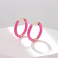 Detailed macro shot of pink enamel hoop earrings with polished golden metallic finish - Rose Pink