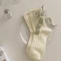 Creamy white cable knit knee-high socks featuring light green silk ribbon bows - One Size / Cream