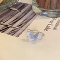 Dettaglio di un anello a farfalla placcato oro con pietre blu e perle artificiali - Argento Farfalla Blu