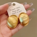 Detailed macro view of vintage brushed gold metallic geometric earrings on display card - 17# Oval Brushed Style