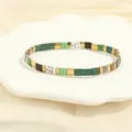 Detailed view of colorful Tila bead bracelets on a white ceramic shell tray decor - Dark Green & Black Set