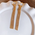 Détail de boucles d'oreilles pendantes dorées à pampilles dans un plat en céramique - Frange Brillante Dorée (Tige en Argent)