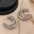 Detailed macro view of triple-layered silver C-shaped hoops with a polished mirror finish - Large C-Shape / Silver
