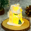 Close-up of glowing miniature Christmas resin house with snow details and LED warm light - Style H