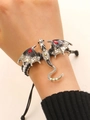 Detail of a dragon bracelet with red gemstone eyes and colored zircons on woven cord - Black White Texture Dragon (H-107) / Antique Silver