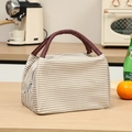 Brown and white striped insulated lunch bag with deep red handles on a wooden table - Khaki Striped