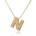Detail of gold letter N pendant with micro-pave champagne zircons on box chain necklace - Letter N