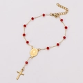 Detailed view of religious rosary bracelet with red faceted beads and golden cross pendant - Gold Red
