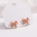 Detail of pink zircon bow earrings with 18K gold plating on a white display card - Rose Gold