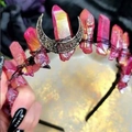 Detail shot of a pink raw crystal moon crown headband held against a dark background - Red Crystal + Black Moon