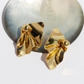 Golden wavy pleated metal earrings with spherical stud detail on shell backdrop - Gold