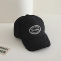 Detailed macro view of the black fleece baseball cap featuring vintage oval embroidery patch - 54-56cm (approx. 4-10 years) / Black