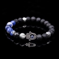 Vista macro del ciondolo Mano di Fatima su bracciale in pietra lavica con riflesso nitido - Sodalite Blu