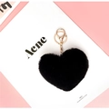 Faux fur heart-shaped keychain in black with gold clasp on aesthetic background - Black