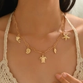 Gold multi-layer necklace with ocean charms like starfish, shells and turtle on model - Ocean Series Multi-Pendant