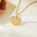 Detail of a gold heart pendant necklace with white zircons on a white stone background - Gold Heart White Zircon Hollow Necklace (T021)