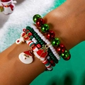 Close-up of beaded Christmas bracelet set with Santa, reindeer and bell charms worn on wrist - Cool Snow Scene Style(27321-colour)