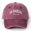 Close-up of Los Angeles white embroidery on a vintage washed purple cotton baseball cap - Burgundy