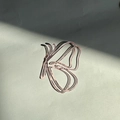 Translucent pink acrylic butterfly cake topper casting elegant shadows on grey background - Rose Gold Butterfly Cutting Style