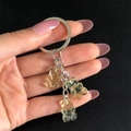 Macro shot of three light yellow jelly resin bears on a silver metal keychain - Light Green