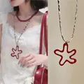 Dettaglio della collana con pendente a stella rossa in resina e cordino bianco e nero - 2# Collana-Caffè-Rosso