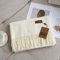 Beige solid cashmere feel scarf with fringe on a cozy sofa background - Milky White 4.6cm