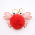 Close-up of a plush crab keychain with red fur ball, pink PU leather claws and golden hook - Red