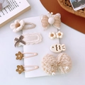 Dettaglio di varie mollette per capelli in peluche beige con fiocchi e fiori per bambine - Stile Farfalla con Paillettes Beige