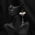Elegant gold butterfly tassel earrings with white pearls and purple stones on a model - Butterfly Style (GE1241)