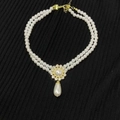 Detailed close-up of double-layer pearl necklace with a rhinestone pendant on black fabric - 24# Gold Pearl Teardrop Necklace