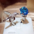 Exquisite hummingbird ring with oval blue gemstone and silver cubic zirconia detailing - White Gold (Blue Main Stone)
