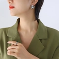 Silberne Blumen-Ohrstecker und Ring mit grünem Edelstein zum olivgrünen Blazer - Stahlfarbe