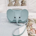 Light blue elephant leather coin purse with lychee texture and wrist strap hanging on a magazine - Light Blue