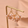Rosafarbene Perlenohrringe in Blumenform mit Goldhaken auf einem edlen Goldständer - Rosa Perlenblüten-Ohrhaken