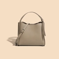 Elegant beige-grey pebble leather bucket bag with adjustable strap and top handle - Premium Grey