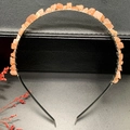 Macro shot of silver metal headband with handmade orange natural stone wire wrapping - Sunstone + Silver Band