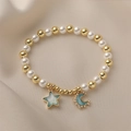 Bracelet en perles dorées et nacrées avec breloques étoile et lune en émail bleu et diamants - Bleu
