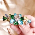 Macro shot of vintage floral enamel hair clip with turquoise rhinestones and gold finish - Blue/Painted Flower