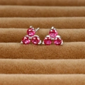 Macro view of clover-shaped stud earrings with pink gemstones on brown velvet - Silver/Rose Red Zirconia