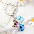 Detail of colorful butterfly keychain featuring three enameled pendants and gold metal ring - Style 3 M741 (Dark Blue/Pink Butterfly)