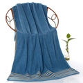 Spessa asciugamano da bagno in cotone blu con strisce colorate su una sedia in vimini - 70x140cm / Blu a righe