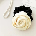 Detail of a creamy satin rose scrunchie with layered fabric petals and pearl necklace - Off White