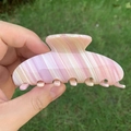 Grande molletta per capelli effetto marmo rosa e crema tenuta su uno sfondo naturale - Righe Crema