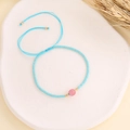 Détail du bracelet bohème en perles bleu ciel avec pierre rose et cordon tressé réglable - Bleu lac