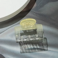 Macro detail of a transparent light green square hair claw clip on textured grey fabric - Square Yellow